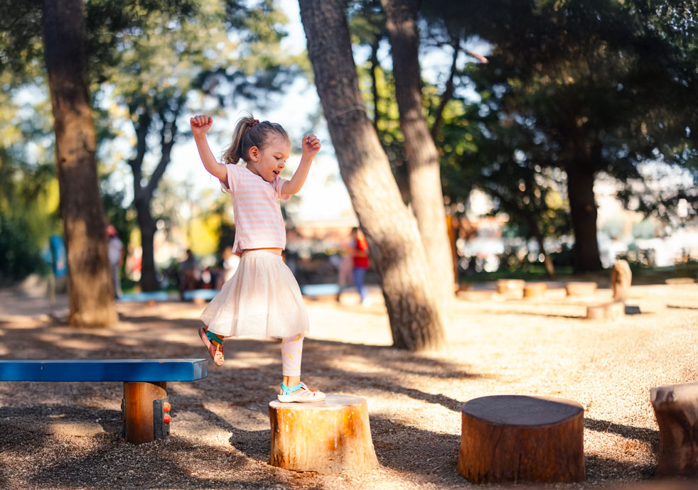 girl playing on stepping stones in park